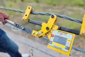 Utility service worker using Dillon Quickcheck clamp on tension meters to measure cable tension